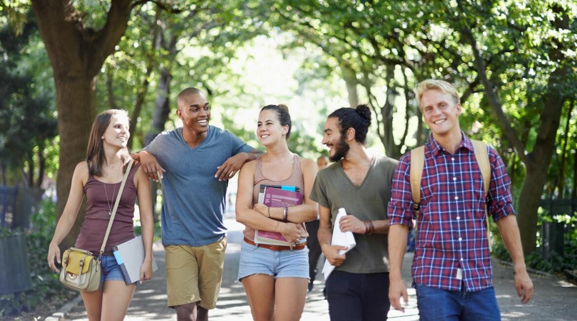 A Group Of Students Walking Down A Path In A Park.